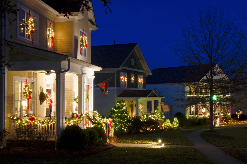 Exterior of homes decorated for Christmas at nighttime